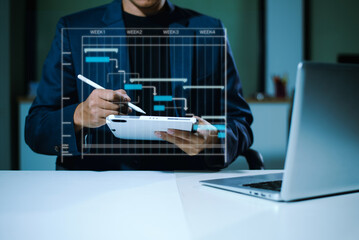 Hands typing on laptop with a digital Gantt chart overlay. Ideal for project planning, scheduling, productivity, workflow