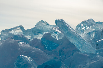 Ice formations with sharp edges and crystalline textures, reflecting light in various shades of...