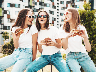 Three young beautiful smiling hipster female in trendy summer same clothes. Sexy carefree women...