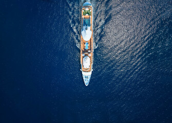 Aerial overhead view of a generic cruise ship sailing over sparkling, blue ocean as a travel...