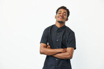 Confident black man smiling with arms crossed, showcasing a relaxed and positive attitude against a...