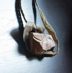 Sling with stone on wooden background
