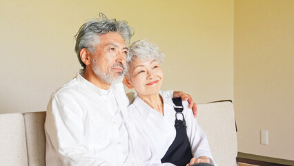 シニア、カップル、夫婦、高齢者、寄り添う、仲良し、お年寄り、リラックス、笑顔、ポジティブ、元気、くつろぐ、室内、熟年、老人、談笑、グレイヘア、白髪、シルバー、中高年、おじいちゃん、おばあちゃん、年配、セカンドライフ、老後、60代、70代、女性、男性、日本人、ヘルスケア、健康、サ高住、老人ホーム、介護、福祉、安心、ハッピー、幸せ、楽しい、コピースペース、リビングルーム、住まい、暮らし、ライフスタイル