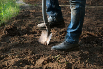 Fototapeta premium Man's feet with a shovel