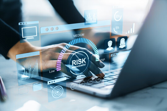 Hands typing on laptop with virtual dashboard interface showing risk management and data analysis for fintech and financial systems concept.