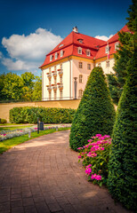 Beautiful morning scene of outskirts of popular tourist destination - Sopot Pier (Molo in Sopot), Poland. Nice summer view of blooming flowers, empty garden and bright building in Dolny Sopot resort.