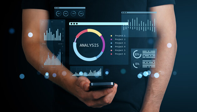 Businessman holding smartphone with futuristic financial dashboard interface for data analysis and KPI tracking on dark digital background.