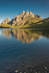 Stunning view of rocky Caucasus mountain peaks reflecting perfectly on a calm alpine lake at...
