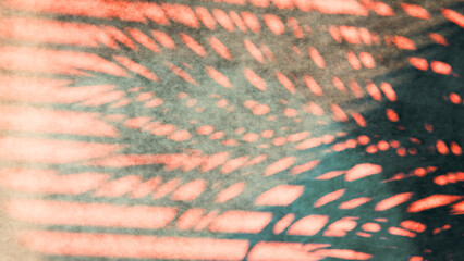 Tropical palm leaf shadowing creating textured coral and green abstract background