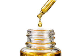 Golden serum drop falling into a bottle.