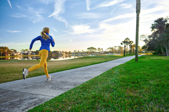 Woman jogging on a scenic pathway in Florida during the morning