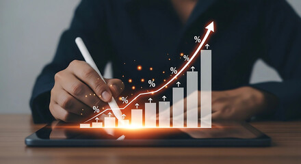 Businessperson using a stylus on a tablet to manipulate an upward trending graph, symbolizing growth and success.