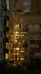 Urban apartment buildings illuminated by warm sunlight during golden hour, showcasing reflections...