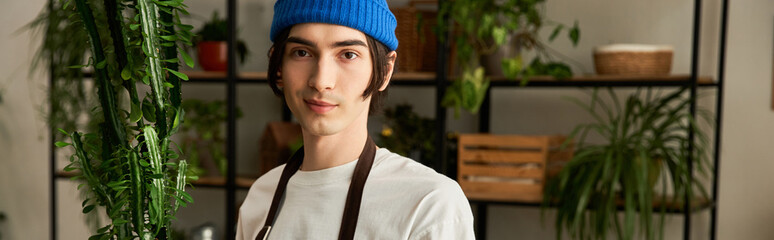 Handsome young man carefully transplanting vibrant plants in bright studio setting