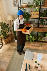Young man nurturing plants with care in a cozy indoor studio environment