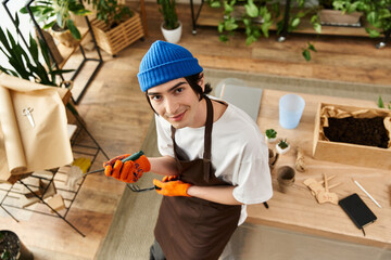 Handsome young man skillfully transplanting plants in a bright studio filled with greenery