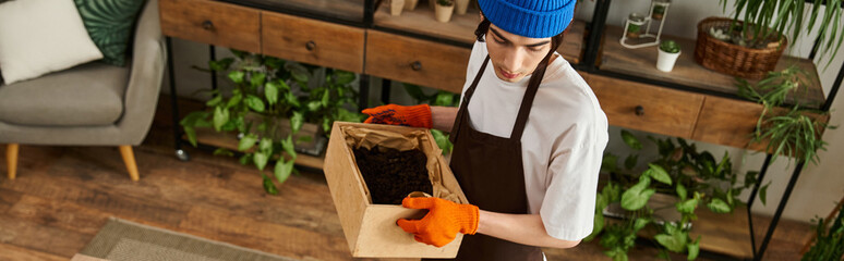 Handsome young man enjoying plant transplanting in a modern studio space