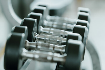 Close-up dumbbells in the gym lie in a row. Fitness