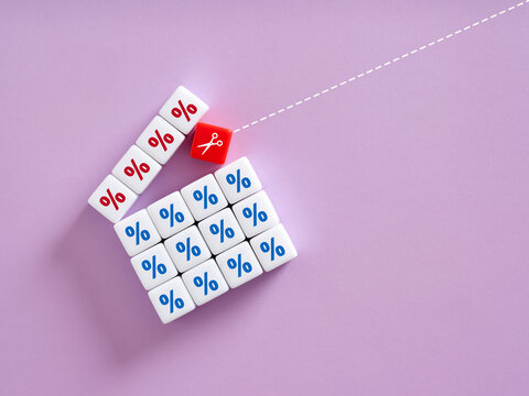 Scissors cutting percentage symbol on red cube separating from others with percentage symbols