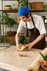 Young man skillfully transplanting vibrant plants in a cozy studio setting filled with greenery