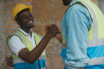 workers at construction site, young engineer manager and worker handshaking at construction site ....