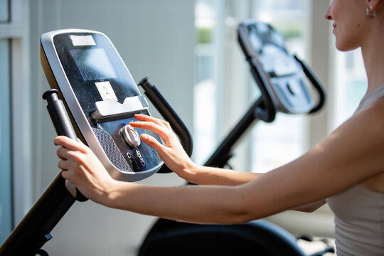 female athlete exercising on stationary bike during her spinning class in a gym. Exercise bike cardio workout at fitness gym of woman taking weight loss with machine aerobic