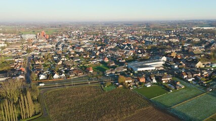 depicts village merchtem belgium train tracks empty green fields rooftops covered snow top old homes roads markets distant horizon scenic urban area infrastructure long view  - Powered by Adobe