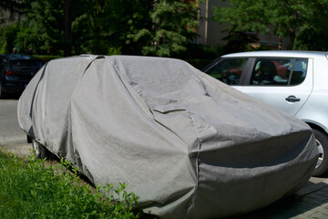Covered car parked on residential street