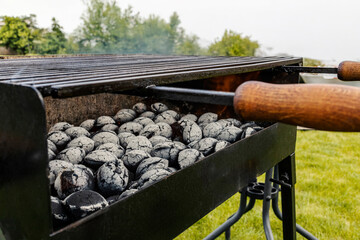 Close up of burning charcoal briquettes in a grill in a backyard.