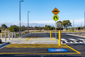 A disabled parking bay in a public car park with a designated pedestrian and accessible crossing....