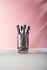 Eyelashes Mascara tubes mockup template in glass on pink background. Unbranded, no label product advertising. Copy space