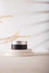 Silver black cream or eye patches jar with no brand, blank label mockup on concrete stairs stand, white background. Product advertising banner, copy space