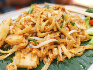 Delicious stir fry noodles with vegetables and seafood on a plate.
Closeup view. Asian cuisine dishes.
