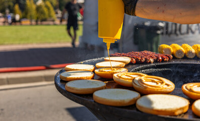 Preparing burgers. The image shows a variety of burger components: toasted buns, sizzling patties,...
