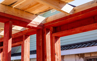 Under-construction residential wooden frame home located near a forest. Commencement of a new...