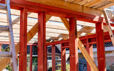 Under-construction residential wooden frame home located near a forest. Commencement of a new...