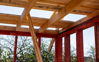 Under-construction residential wooden frame home located near a forest. Commencement of a new...