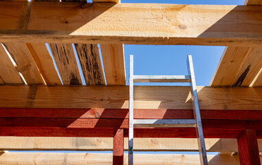 Under-construction residential wooden frame home located near a forest. Commencement of a new...