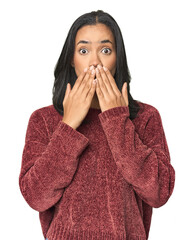 Simple portrait of a young Latina shocked, covering mouth with hands, anxious to discover something...