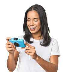 Latina with vintage camera in a studio setting