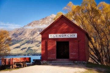 Scenic view of Glenorchy building by the lake surrounded by mountains and autumn trees