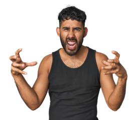 Young Hispanic man isolated upset screaming with tense hands.