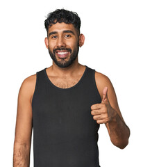 Young Hispanic man isolated smiling and raising thumb up