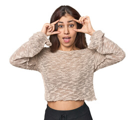 Middle Eastern woman in studio keeping eyes opened to find a success opportunity.