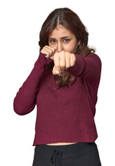 Middle Eastern woman in studio throwing a punch, anger, fighting due to an argument, boxing.