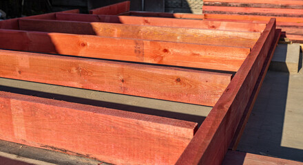Close-up of a wooden frame for a new construction project. The frame rests on a concrete...