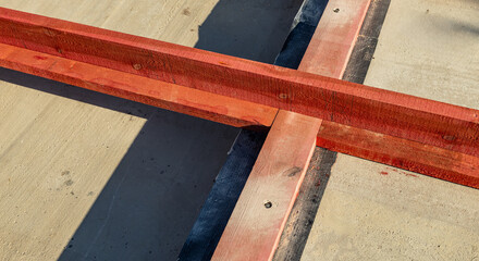 Close-up of a wooden frame for a new construction project. The frame rests on a concrete...