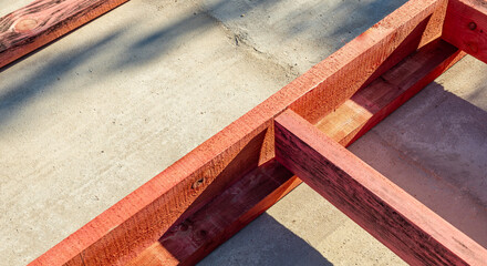 Close-up of a wooden frame for a new construction project. The frame rests on a concrete...