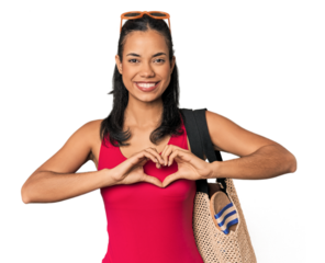 Young Filipina with beach bag smiling and showing a heart shape with hands.