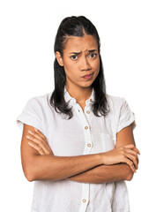 Young Filipina woman suspicious, uncertain, examining you.